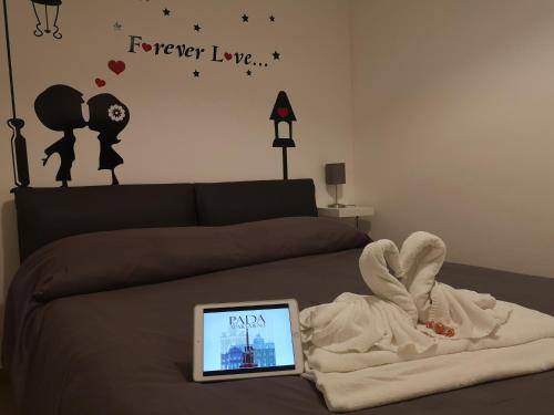una camera con un letto, un asciugamano e un computer portatile di PADA Apartment a Catania