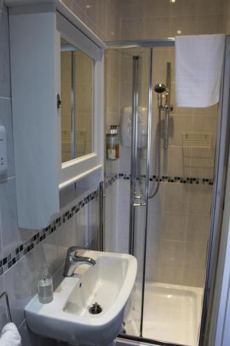 a bathroom with a sink and a shower at Beamsley Lodge B&B in Eastbourne