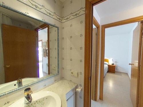 y baño con lavabo y espejo. en Atico Duplex Coral, en Sitges