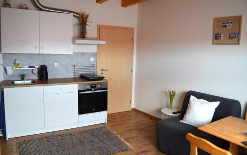 a kitchen with a table and a couch in a room at Apartmány Réví in Hlohovec