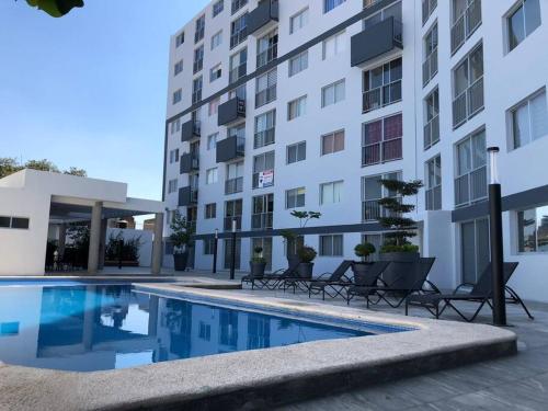 a hotel swimming pool in front of a building at Be Central Departamento con alberca en el centro de Guadalaja in Guadalajara
