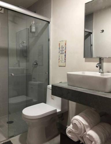 a bathroom with a toilet and a sink and a shower at Be Central Departamento con alberca en el centro de Guadalaja in Guadalajara