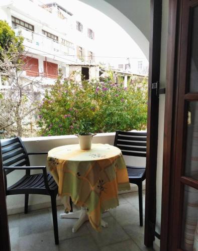 a table and chairs on a balcony with a plant at Katerina Studios in Naxos Chora
