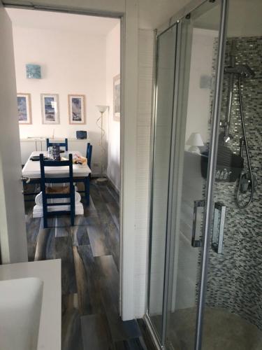 un bagno con doccia e una sala da pranzo con tavolo di Maison Turquoise a Cala Gonone