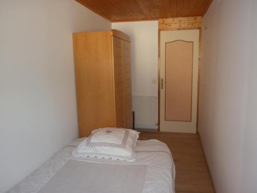 a small bedroom with a bed and a wooden door at Villa du soleil levant in Apt