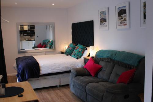 a bedroom with a bed and a couch at The Nook @ Applemede in Chudleigh