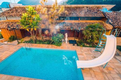 a swimming pool in front of a house at Hotel Serra Everest in Nova Friburgo