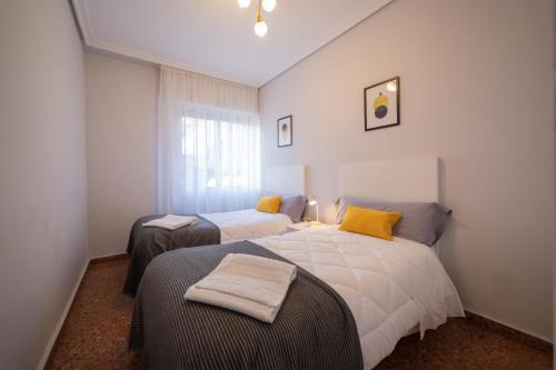 1 dormitorio con 2 camas y ventana en Apartamento Albelda Plaza, en Albelda de Iregua