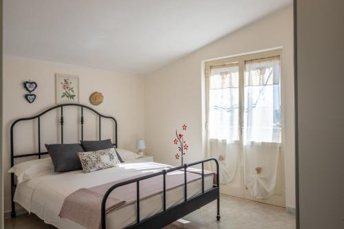 Leporano MarinaにあるB&B DANIELAの白いベッドルーム(ベッド1台、窓付)