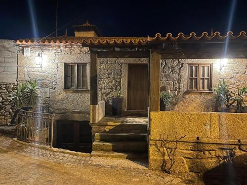 a stone house with a door in a street at night at Casa da Aldeia in Azevo