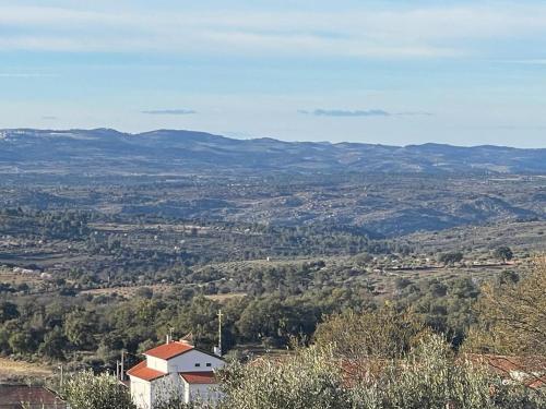a view of a valley with a house and mountains at Casa da Aldeia in Azevo