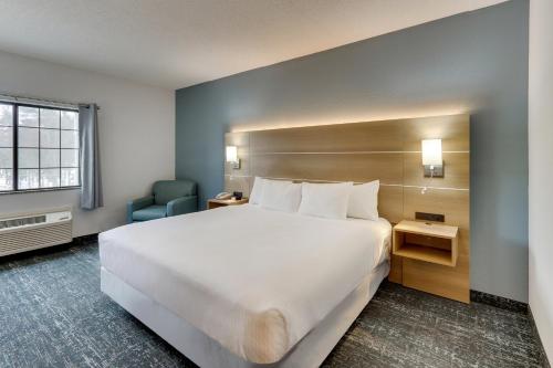 a hotel room with a large bed and a chair at Parkshore Resort in Traverse City