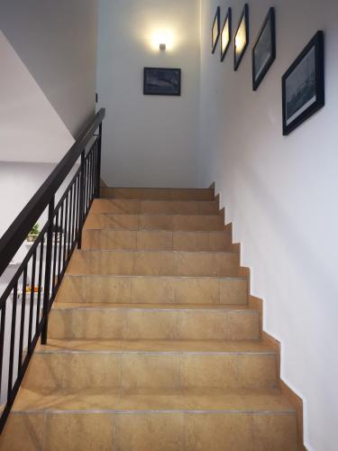a staircase with wooden steps and white walls at 48 悠之处NO . 48, PERSIARAN ALAM IMPIAN 3 VILLA RIADAH ALAM IMPIAN PANGKOR, 32300 PANGKOR , PERAK. in Pangkor