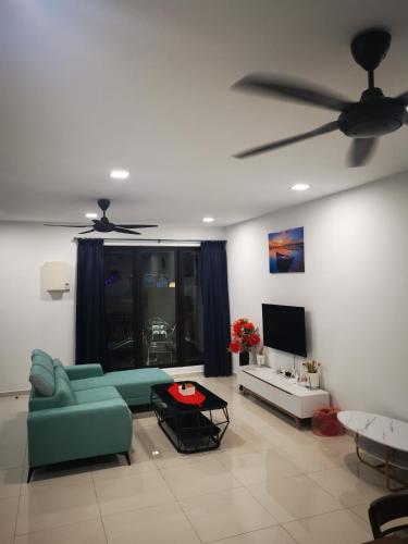 a living room with a green couch and a ceiling fan at 48 悠之处NO . 48, PERSIARAN ALAM IMPIAN 3 VILLA RIADAH ALAM IMPIAN PANGKOR, 32300 PANGKOR , PERAK. in Pangkor