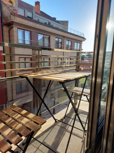 a table on the balcony of a building at APARTAMENTO GUIMAREY in Sanxenxo