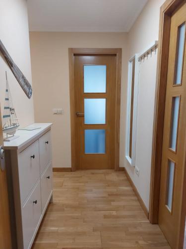 a kitchen with a door and a wooden floor at APARTAMENTO GUIMAREY in Sanxenxo