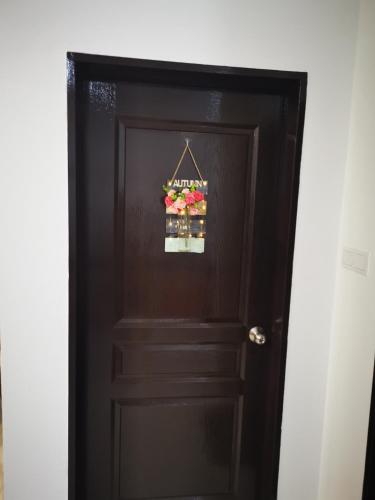 a brown door with a bunch of flowers on it at 48 悠之处NO . 48, PERSIARAN ALAM IMPIAN 3 VILLA RIADAH ALAM IMPIAN PANGKOR, 32300 PANGKOR , PERAK. in Pangkor