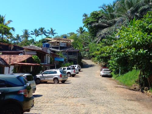 a group of cars parked on a dirt road at Chalé na Praia da Tiririca in Itacaré