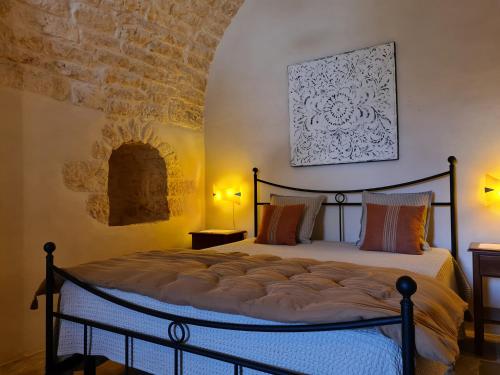 una camera con un letto in una stanza con un muro di mattoni di Masseria Montecchie a Ceglie Messapica