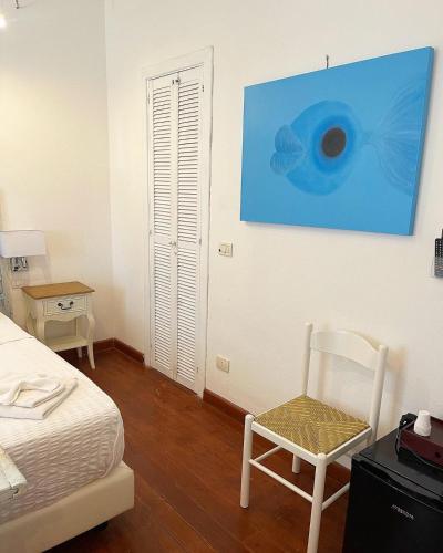 a bedroom with a bed and a blue painting on the wall at Dolce Vita Suite Alghero in Alghero