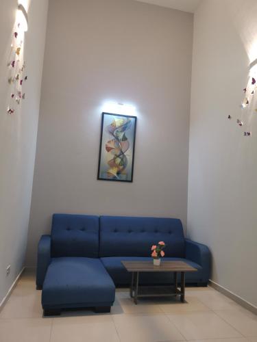 a living room with a blue couch and a table at 48 悠之处NO . 48, PERSIARAN ALAM IMPIAN 3 VILLA RIADAH ALAM IMPIAN PANGKOR, 32300 PANGKOR , PERAK. in Pangkor