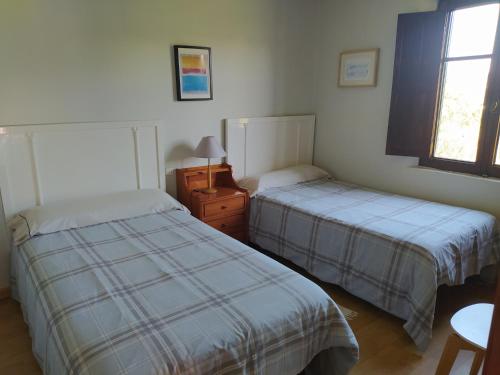 een slaapkamer met 2 bedden en een raam bij Casa Torás in Vilagarcia de Arousa