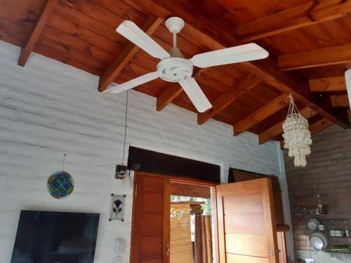 ventilador de techo en la sala de estar con TV en Cabañas Farah Estancia Vieja ideal para 2, en Villa Carlos Paz