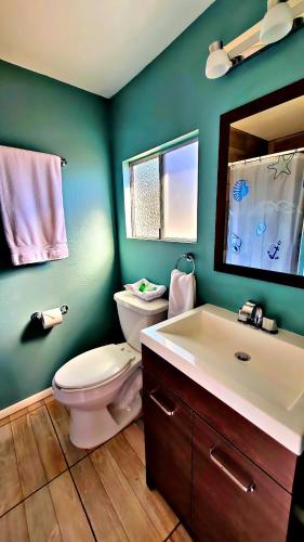 y baño con aseo, lavabo y espejo. en Popotla Room #4, en Divisadero