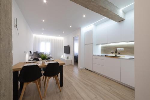 eine Küche und ein Esszimmer mit einem Tisch und Stühlen in der Unterkunft Apartamento Ayuntamiento Av de La Paz in Logroño