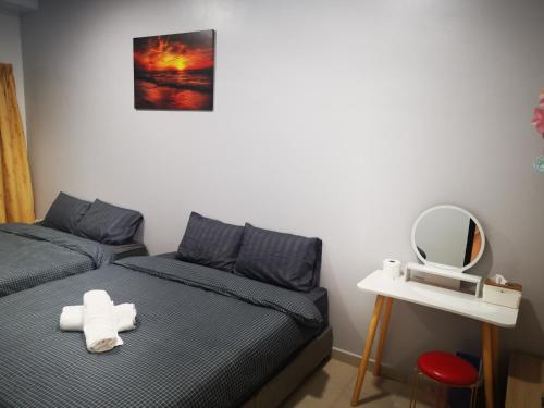 a room with two beds and a mirror and a mirror at 48 悠之处NO . 48, PERSIARAN ALAM IMPIAN 3 VILLA RIADAH ALAM IMPIAN PANGKOR, 32300 PANGKOR , PERAK. in Pangkor