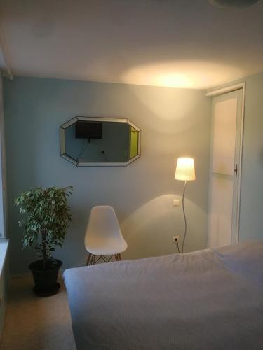 1 dormitorio con 1 cama y TV en la pared en Arbois, joli petit appartement plein centre, en Arbois