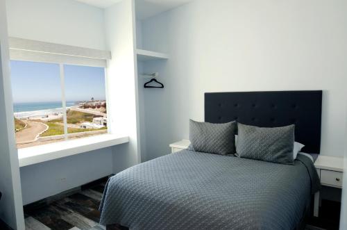 a bedroom with a bed and a large window at Popotla Villa #203 in Divisadero