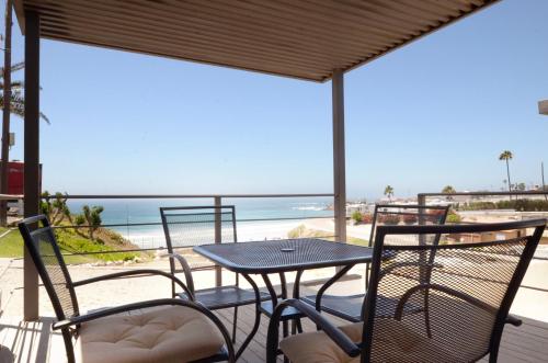 un patio con mesa y sillas y la playa en Popotla Villa #203, en Divisadero