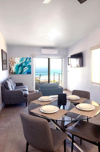 una sala de estar con mesa y sillas y el océano en Popotla Villa #203, en Divisadero