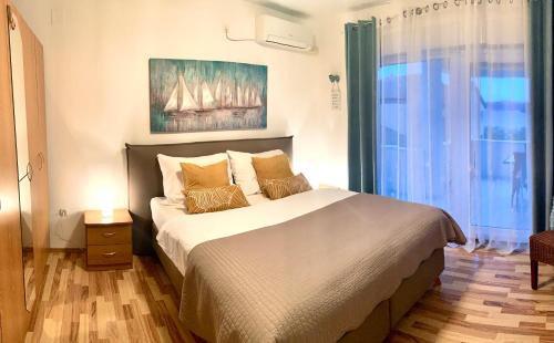 a bedroom with a bed and a painting on the wall at Apartment Lucie3 in Biograd na Moru