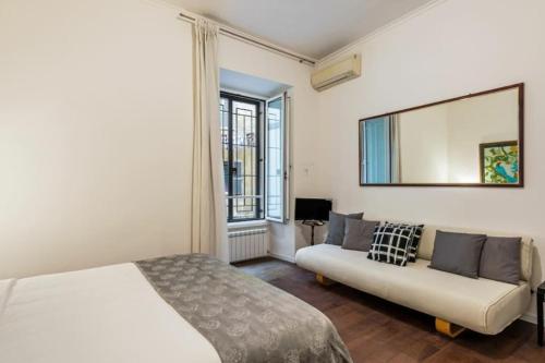 ein Schlafzimmer mit einem Bett, einem Sofa und einem Spiegel in der Unterkunft Pop Corn House in Rom