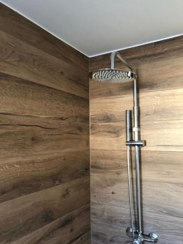 a shower in a bathroom with wooden walls at Maximo Apartments - free parking in Maribor