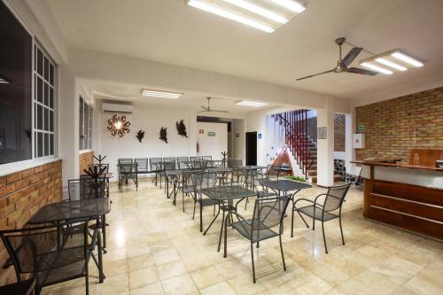 um grupo de mesas e cadeiras numa sala em Hostería Poza Rica em Poza Rica de Hidalgo