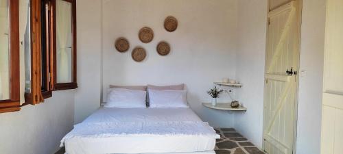 1 dormitorio con cama blanca y espejo en Lithos Residence, en Paltsi Pilion