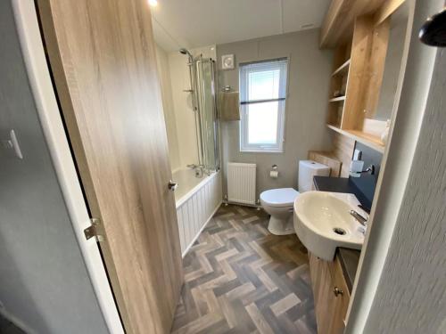 a bathroom with a sink and a toilet and a shower at ELITE BLUE LUXURY 3 BEDROOM LODGE NEWQUAY, CORNWALL in Newquay