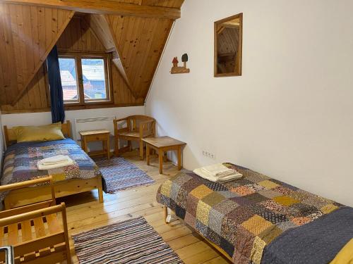 Casa Bucataria Fonix في براد: غرفة نوم بسريرين وطاولة وكراسي