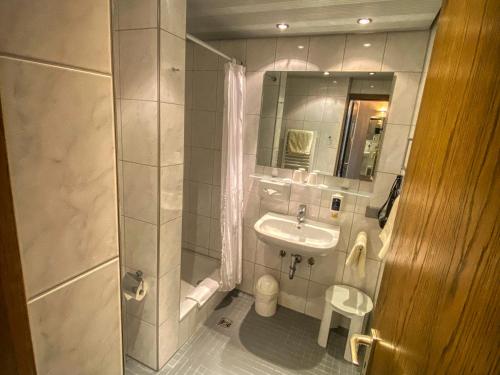 a small bathroom with a sink and a mirror at City Partner Hotel Berliner Hof in Karlsruhe