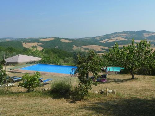 une piscine dans un champ avec des montagnes en arrière-plan dans l'établissement Villa with private swimming pool and private garden in quiet area, panoramic views, à Radicondoli