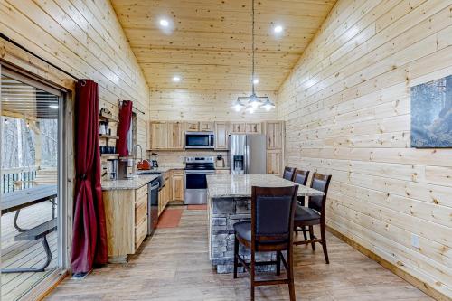 a kitchen with wooden walls and a table and chairs at Cozy Bear Cabin #2 in Sautee Nacoochee