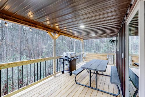 a screened in porch with a picnic table on the deck at Cozy Bear Cabin #2 in Sautee Nacoochee