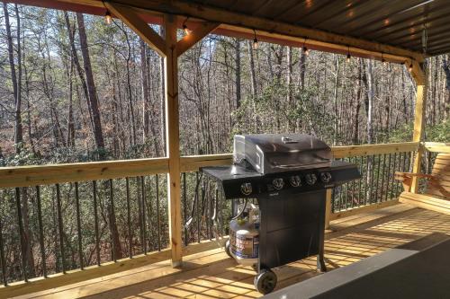a grill on a screened in porch in the woods at Cozy Bear Cabin #2 in Sautee Nacoochee