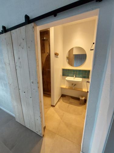 a bathroom with a door leading to a sink at Champs Erezée , genieten in elk seizoen in Érezée