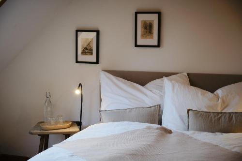a bedroom with a bed with white sheets and pillows at Aigen 13 - Dreiviertelhof im Waldviertel in Aigen