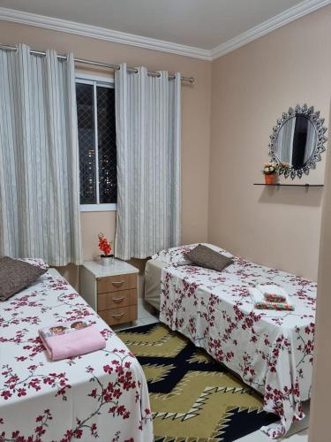 a bedroom with two beds and a mirror and a window at Life Ponta Negra in Manaus
