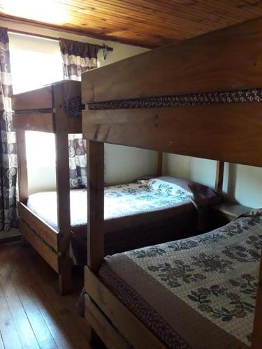 מיטה או מיטות קומותיים בחדר ב-Cabañas Familiares Puente de Tralca 6